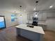 Kitchen island with quartz countertop, undermount stainless sink, and pendant lights, connecting to breakfast area at 3037 Abelia Dr, Buford, GA 30519