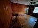 Living area with wood paneling, built-in shelves, and linoleum flooring, enhanced by natural light from the window at 3195 Benjamin E Mays Sw Dr, Atlanta, GA 30311