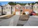 A view of a brick townhome with a single car garage and a long driveway at 418 Lantern Wood Dr, Scottdale, GA 30079