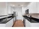 Bright kitchen featuring stainless steel appliances, ample white cabinetry, and black countertops at 418 Lantern Wood Dr, Scottdale, GA 30079