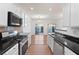 Galley kitchen featuring stainless steel appliances and black countertops at 418 Lantern Wood Dr, Scottdale, GA 30079