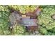 An aerial view of the home and a large deck for outdoor entertaining surrounded by lush trees at 150 Melody Ln, Fayetteville, GA 30215
