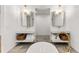 Bright bathroom features a soaking tub, dual vanities with gold fixtures, and stone flooring at 150 Melody Ln, Fayetteville, GA 30215