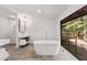 Spa bathroom with soaking tub, walk-in shower, gold fixtures, and picturesque forest view at 150 Melody Ln, Fayetteville, GA 30215
