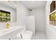 Modern bathroom with sleek white sink and gold fixtures and a window with wooded view at 150 Melody Ln, Fayetteville, GA 30215