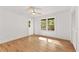 Bright bedroom boasts hardwood floors, neutral paint, ceiling fan, and windows overlooking outdoors at 150 Melody Ln, Fayetteville, GA 30215