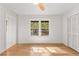 Bright bedroom boasts hardwood floors, neutral paint, and windows overlooking a forest view at 150 Melody Ln, Fayetteville, GA 30215