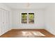 Bright bedroom features a window overlooking a wooded area and a double closet with paneled doors at 150 Melody Ln, Fayetteville, GA 30215