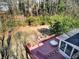 Aerial view of a home featuring a large yard, deck, screened in porch, and wooded surroundings at 1938 Kelvin Dr, Lawrenceville, GA 30043