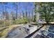 Backyard with a fire pit and patio area surrounded by lush trees and greenery at 1938 Kelvin Drive Dr, Lawrenceville, GA 30043