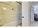 Updated bathroom with tiled walls, glass enclosed shower over tub, and open door to bedroom at 1938 Kelvin Dr, Lawrenceville, GA 30043