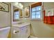 Bright bathroom features a white vanity, a mirror, and a window with a woven shade at 1938 Kelvin Dr, Lawrenceville, GA 30043