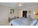 Cozy bedroom with neutral walls, ceiling fan, artwork, and a doorway to another room at 1938 Kelvin Drive Dr, Lawrenceville, GA 30043