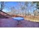 Inviting wooden deck with a railing, table, and views of the surrounding wooded area at 1938 Kelvin Dr, Lawrenceville, GA 30043