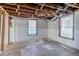 Unfinished basement space featuring exposed ceiling beams, two windows, and concrete walls at 238 Howell Sw Dr, Atlanta, GA 30331