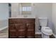 This is a bathroom with wood-look flooring, a vanity, and a toilet at 238 Howell Sw Dr, Atlanta, GA 30331