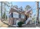 Attractive brick home featuring a front porch, rooftop deck, and well-manicured landscaping at 238 Howell Sw Dr, Atlanta, GA 30331