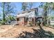 Side exterior of the two-story home with brick and siding featuring a balcony and mature trees around the yard at 238 Howell Sw Dr, Atlanta, GA 30331