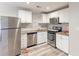 Well-lit kitchen with stainless steel appliances, granite counters, white cabinets and wood-look floors at 2631 Santa Barbara Nw Dr, Atlanta, GA 30318