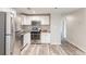This renovated kitchen features stainless steel appliances, white cabinets, granite countertops and wood-look flooring at 2631 Santa Barbara Nw Dr, Atlanta, GA 30318