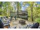 A stone fire pit and seating complement the lush, wooded backyard at 275 Waverly W Trce, Roswell, GA 30075