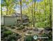 A serene backyard oasis showcases a fire pit area with ample seating nestled amongst the trees at 275 Waverly W Trce, Roswell, GA 30075