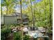 This backyard features a round patio and seating, all surrounded by lush greenery and mature trees at 275 Waverly W Trce, Roswell, GA 30075