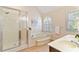 Bright bathroom with a bathtub, a separate shower, and a double sink vanity with a granite countertop at 312 River Glen Dr, Roswell, GA 30075