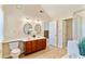 Bright bathroom has a double sink vanity with framed oval mirrors and modern lighting at 312 River Glen Dr, Roswell, GA 30075