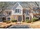 Charming townhome featuring a brick facade, complemented by stylish gray accents, lush landscaping, and inviting entrance at 312 River Glen Dr, Roswell, GA 30075