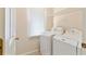 Functional laundry room with a side-by-side washer and dryer and overhead storage at 312 River Glen Dr, Roswell, GA 30075