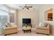 Cozy living room featuring comfortable seating, a ceiling fan, and natural light from the windows at 312 River Glen Dr, Roswell, GA 30075