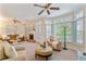 Inviting living room featuring a cozy brick fireplace, neutral tones, lots of light, and a ceiling fan at 312 River Glen Dr, Roswell, GA 30075