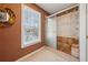 Modern bathroom featuring a glass-enclosed shower with tile surround, a window, and stone flooring at 1043 Sugar Pike Way, Canton, GA 30115