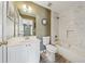 Bathroom featuring a single vanity sink, white marble-look shower, and wood-look tile flooring at 1043 Sugar Pike Way, Canton, GA 30115