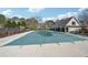 Community pool featuring a safety cover and nearby cabana with picnic tables, surrounded by trees and a fence at 1043 Sugar Pike Way, Canton, GA 30115
