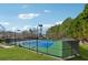 This amazing tennis court features well-maintained green and blue playing surfaces, surrounded by a secure fence and lush landscaping at 1043 Sugar Pike Way, Canton, GA 30115