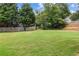 Expansive backyard features lush green grass, privacy fence, mature trees and tiered retaining wall at 112 Timber Mist Ln, Lawrenceville, GA 30045