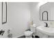 Modern half bathroom features a sleek black faucet, stylish mirror, and decorative artwork at 112 Timber Mist Ln, Lawrenceville, GA 30045
