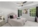 Comfortable bedroom features an accent mirror, large windows with coverings and modern fan at 112 Timber Mist Ln, Lawrenceville, GA 30045