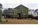 Green two-story home featuring an expansive wooden deck, perfect for entertaining, and a spacious backyard at 2102 Bedford Ct, Lithonia, GA 30058