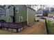 Exterior view featuring a spacious backyard, a wooden deck, and a well-maintained lawn, perfect for outdoor activities at 2102 Bedford Ct, Lithonia, GA 30058