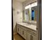 Well-lit bathroom featuring a double mirror over vanity with white cabinets and speckled granite countertop at 2102 Bedford Ct, Lithonia, GA 30058