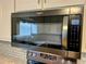 Stainless steel microwave with gray subway tile backsplash and stainless steel stove top at 2102 Bedford Ct, Lithonia, GA 30058