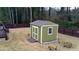 Side view of the backyard shed surrounded by trees and grass at 2102 Bedford Ct, Lithonia, GA 30058
