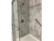 Shower with a glass door, marble-patterned surround and convenient shelves at 2102 Bedford Ct, Lithonia, GA 30058