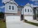 Charming townhome with blue siding, brick accents, and a two-car garage, perfect for modern living at 344 Sinclair Ct # 74, Mcdonough, GA 30253