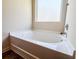 A modern bathroom featuring a white corner bathtub with chrome fixtures and frosted window at 1291 Vienna Ct, Hampton, GA 30228