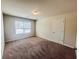 This bedroom has carpet, a window that allows natural light, and a closet to provide a simple and functional space at 1291 Vienna Ct, Hampton, GA 30228