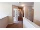 Bright hallway featuring neutral walls, carpeted floors, and open doorways into bedrooms, offering a welcoming transition between rooms at 1291 Vienna Ct, Hampton, GA 30228